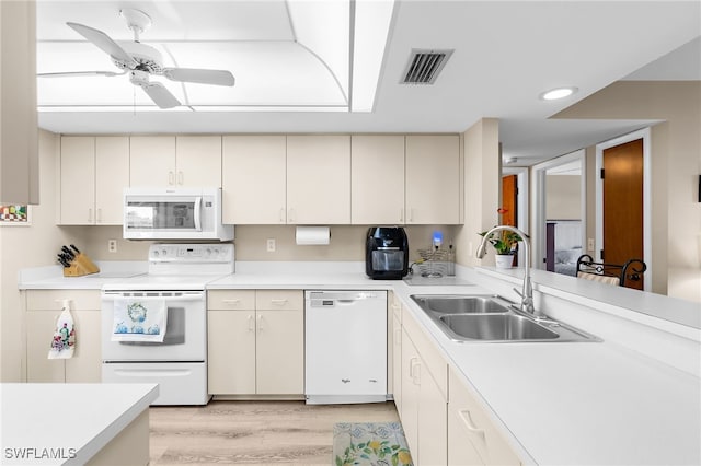 kitchen with white appliances, light countertops, visible vents, and a sink