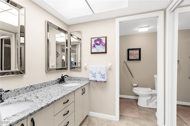 bathroom with tile patterned flooring, toilet, baseboards, and a sink