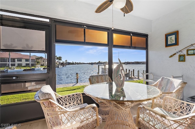 sunroom / solarium featuring a wealth of natural light, a water view, and a ceiling fan