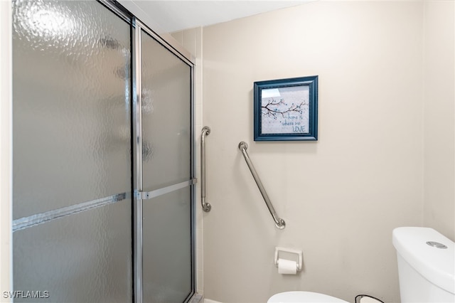 bathroom with toilet and a stall shower