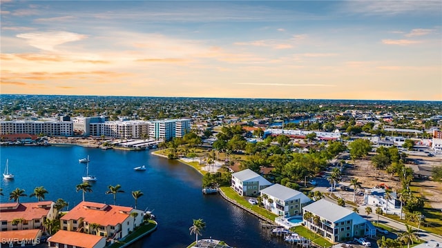 aerial view at dusk featuring a water view