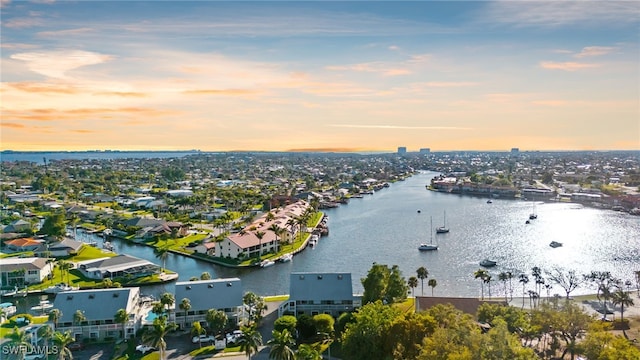 aerial view at dusk featuring a water view