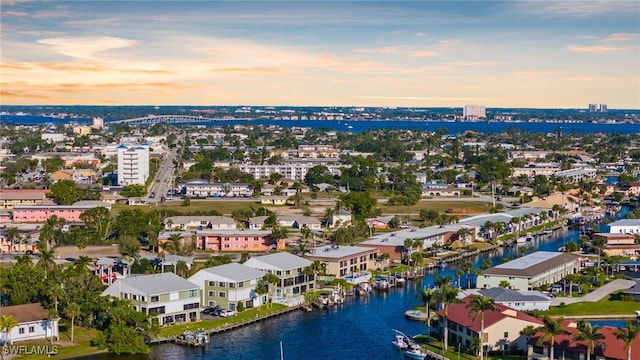 aerial view at dusk featuring a water view