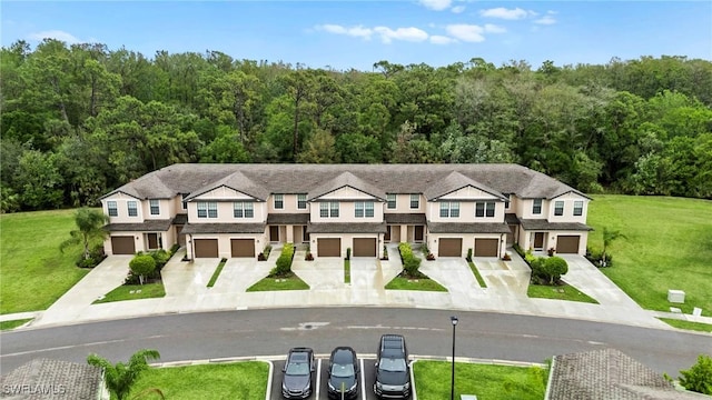 view of front facade with a front lawn, a garage, and driveway