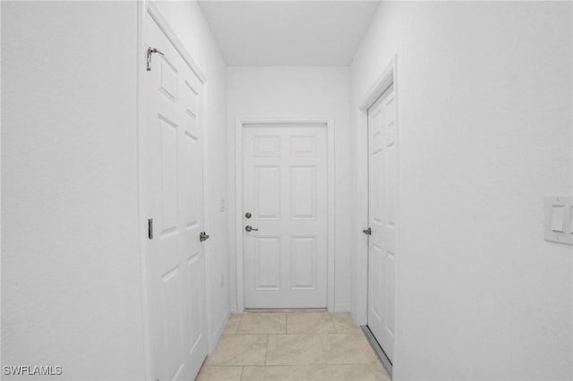 hall featuring light tile patterned floors