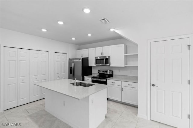 kitchen featuring a center island with sink, visible vents, open shelves, white cabinets, and appliances with stainless steel finishes