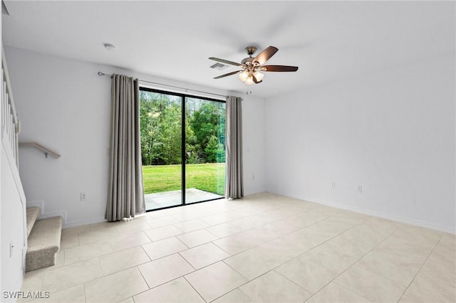 empty room with stairway, light tile patterned flooring, a ceiling fan, and visible vents