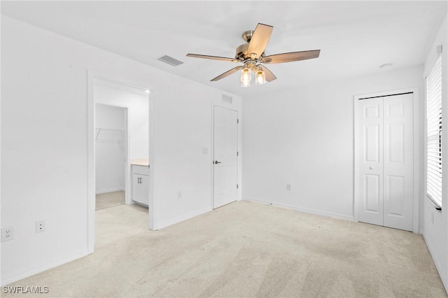 unfurnished bedroom with visible vents, light colored carpet, and a closet