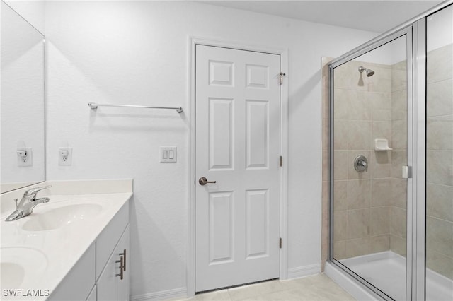 bathroom featuring double vanity, tile patterned floors, a stall shower, and a sink