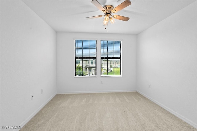 spare room featuring baseboards, carpet, and a ceiling fan