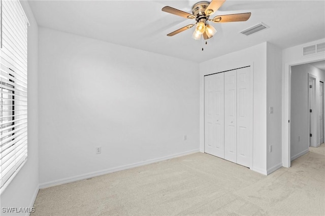 unfurnished bedroom featuring visible vents, baseboards, light colored carpet, and a closet