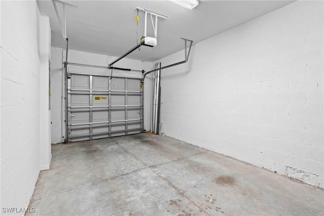 garage with concrete block wall and a garage door opener