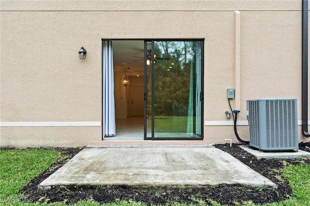 doorway to property with central air condition unit and stucco siding