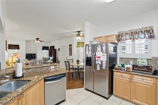 kitchen featuring light tile patterned floors, stainless steel appliances, ceiling fan, and a sink