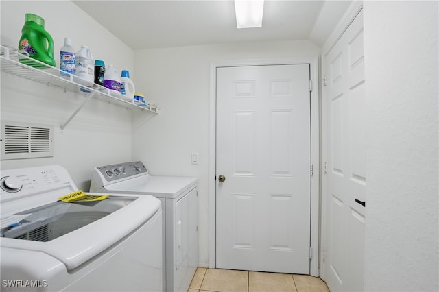 laundry room featuring light tile patterned floors, visible vents, separate washer and dryer, and laundry area