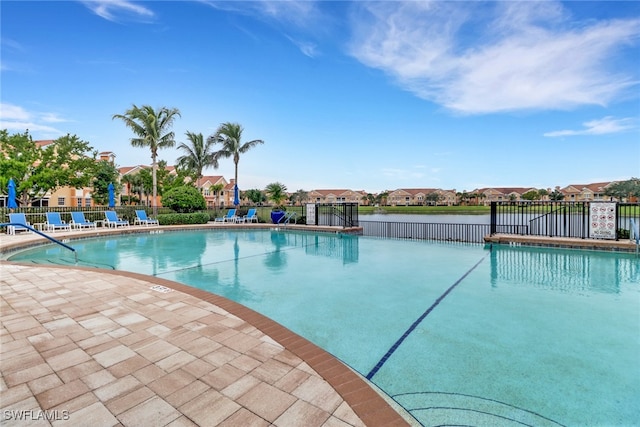 pool featuring a residential view, a patio, and fence