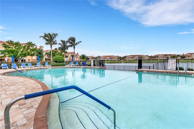 community pool featuring a patio area, a residential view, and fence