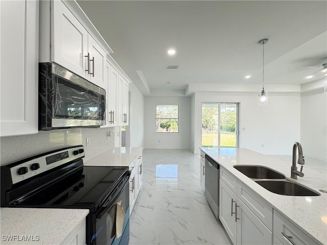 kitchen featuring light stone countertops, recessed lighting, appliances with stainless steel finishes, marble finish floor, and a sink