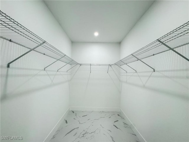 walk in closet with marble finish floor