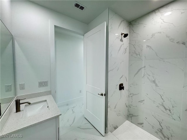 bathroom with a marble finish shower, marble finish floor, vanity, and visible vents