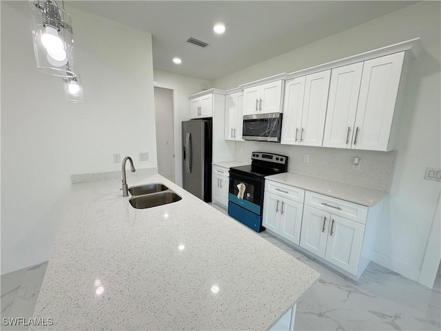 kitchen featuring marble finish floor, a sink, appliances with stainless steel finishes, white cabinets, and light stone countertops