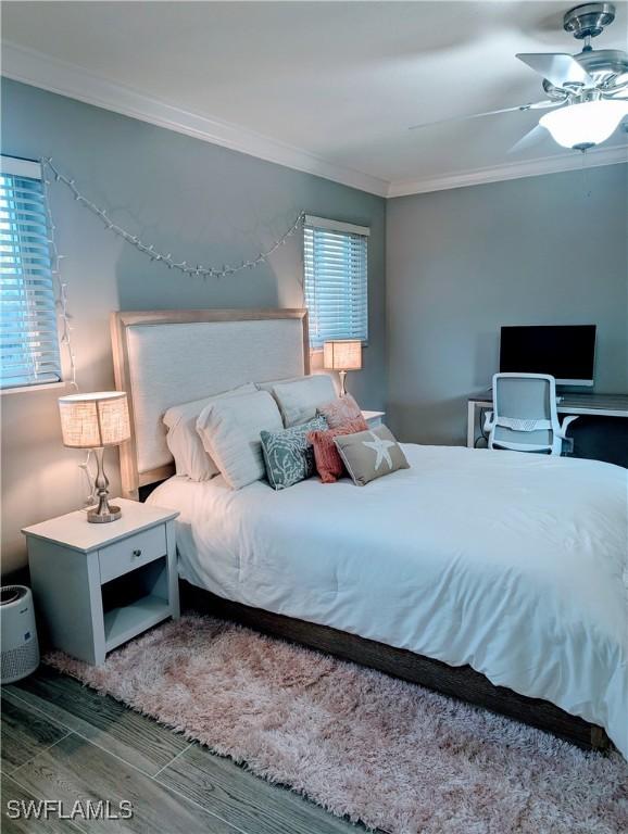 bedroom with a ceiling fan, wood finish floors, and ornamental molding