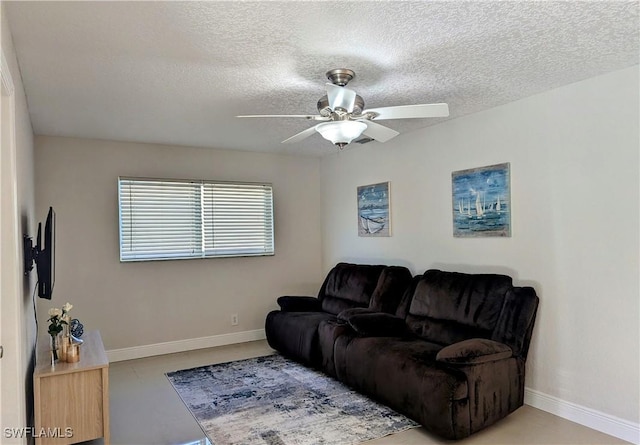 living area with a textured ceiling, baseboards, and ceiling fan