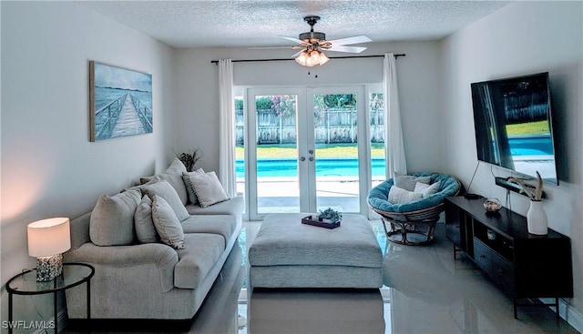 living area featuring a textured ceiling, plenty of natural light, french doors, and ceiling fan