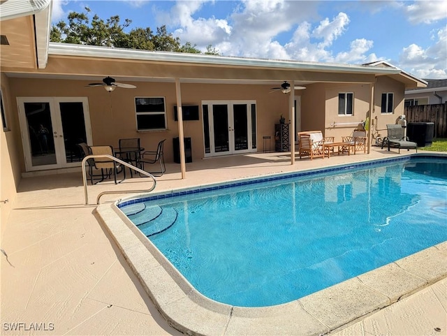 view of swimming pool with a patio, a fenced in pool, fence, ceiling fan, and french doors