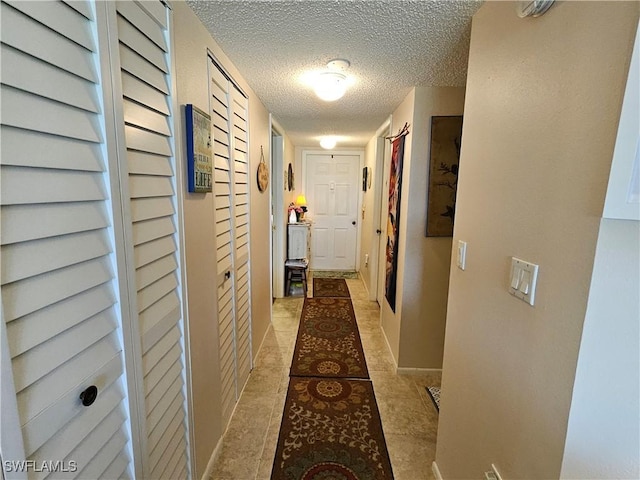 hall featuring a textured ceiling