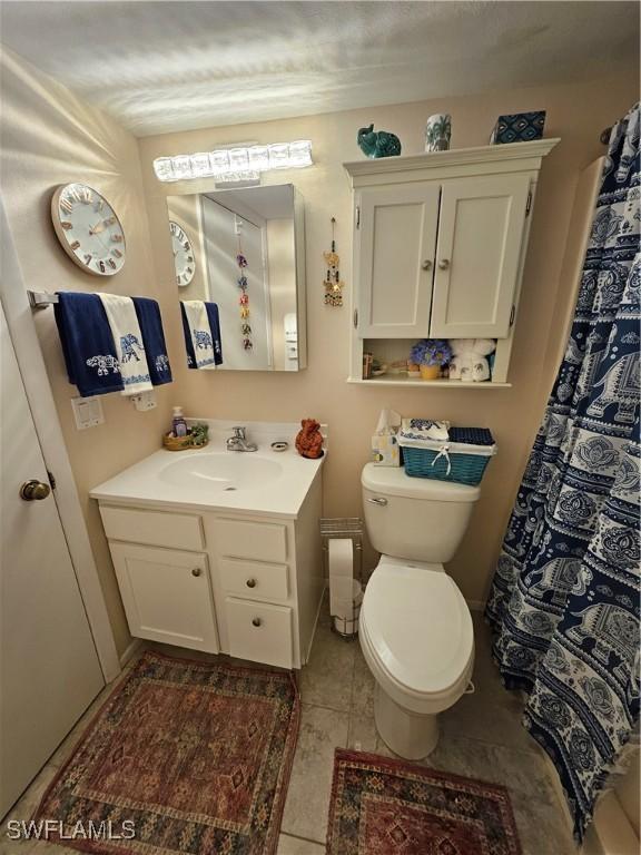 bathroom featuring toilet, vanity, and tile patterned flooring