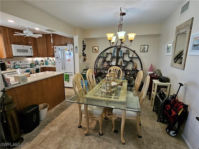 dining space with visible vents, ceiling fan with notable chandelier, a textured ceiling, and tile patterned flooring