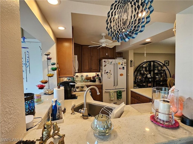 kitchen featuring visible vents, light countertops, freestanding refrigerator, and a sink