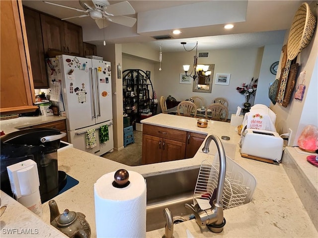 kitchen featuring ceiling fan with notable chandelier, decorative light fixtures, visible vents, and high end white fridge