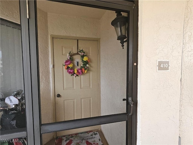 doorway to property featuring stucco siding