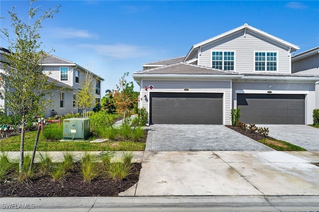 traditional home featuring decorative driveway and a garage