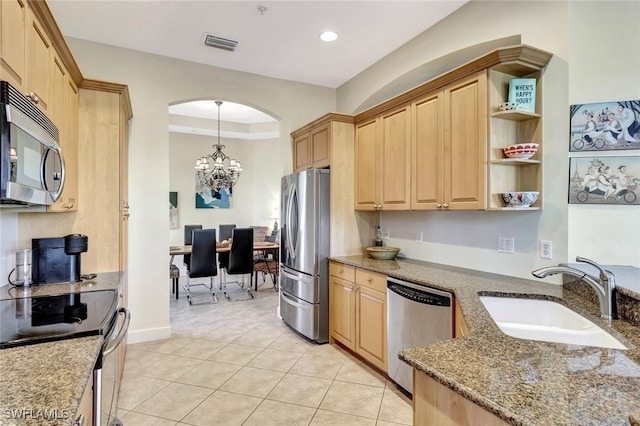 kitchen with light brown cabinetry, a chandelier, appliances with stainless steel finishes, and a sink