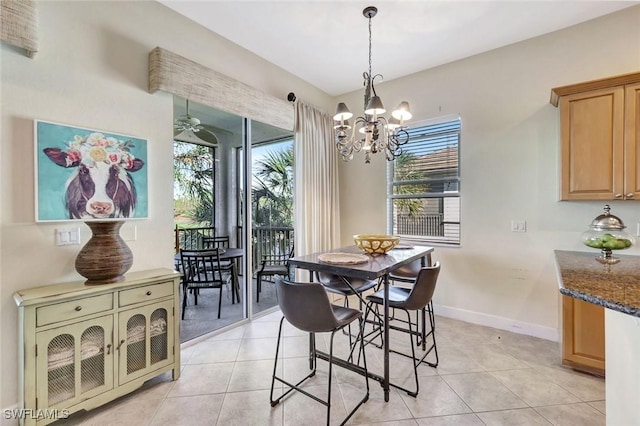 dining space with a notable chandelier, light tile patterned flooring, and baseboards