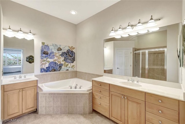 ensuite bathroom featuring a sink, a garden tub, a stall shower, and tile patterned floors