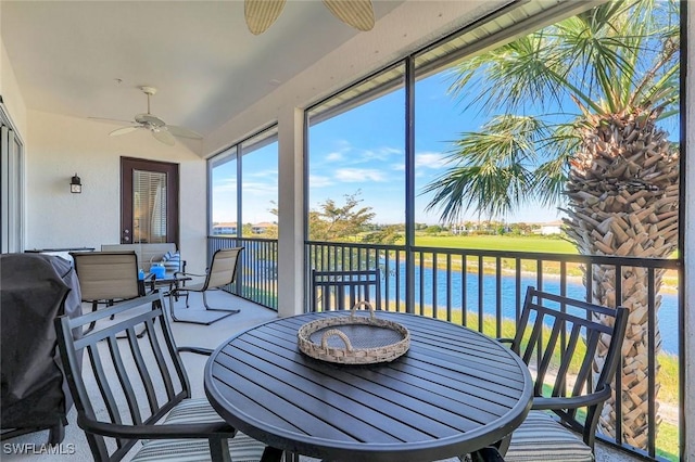 sunroom / solarium with a water view and ceiling fan