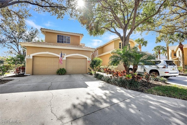 view of front facade featuring a garage, driveway, and stucco siding