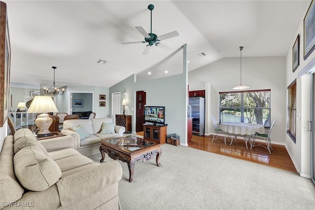 carpeted living area featuring visible vents, baseboards, high vaulted ceiling, and ceiling fan with notable chandelier