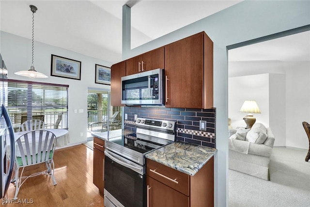 kitchen featuring wood finished floors, stone counters, hanging light fixtures, appliances with stainless steel finishes, and backsplash