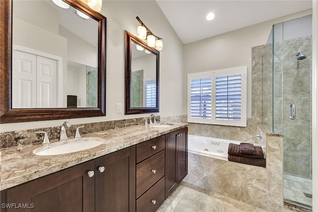 bathroom with double vanity, a shower stall, a jetted tub, and a sink