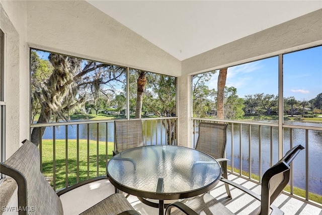 sunroom featuring lofted ceiling and a water view