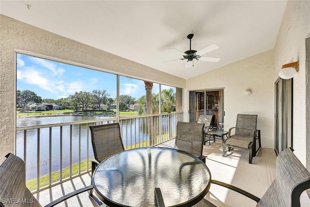 sunroom featuring a water view, ceiling fan, and vaulted ceiling