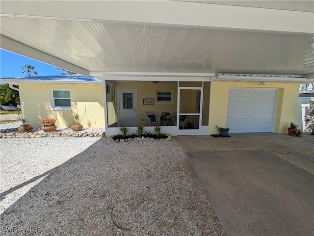 view of front of home with a garage, driveway, and stucco siding