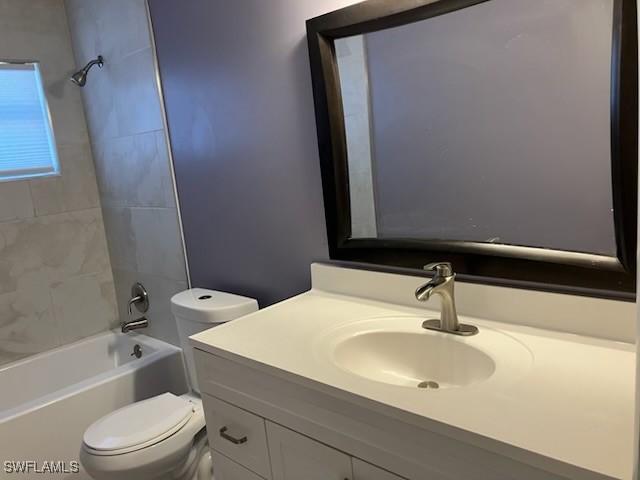 bathroom featuring shower / bathtub combination, toilet, and vanity