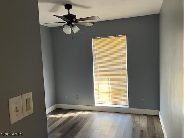 unfurnished room with a ceiling fan, baseboards, and wood finished floors