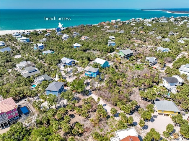 drone / aerial view featuring a beach view and a water view